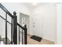 Inviting home foyer featuring clean, white walls, light floors and a contrasting black stair railing at 244 Victor Ct, Garner, NC 27529