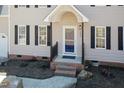 Close up of home's front entry with a storm door and brick stairs surrounded by new landscaping at 244 Victor Ct, Garner, NC 27529