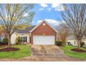 Charming brick home featuring an attached garage, inviting entrance, and manicured lawn at 2524 Forest Shadows Ln, Raleigh, NC 27614