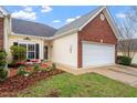 Charming brick home featuring an attached garage, inviting entrance, and manicured lawn at 2524 Forest Shadows Ln, Raleigh, NC 27614