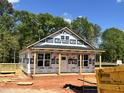 New home under construction with a covered porch and lumber deck showcasing the building process at 274 Longbow Dr, Middlesex, NC 27557