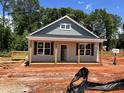 Charming single-story home with gray siding, wood columns, and a cozy front porch under a bright blue sky at 274 Longbow Dr, Middlesex, NC 27557