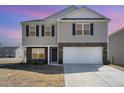 Two story home featuring a two-car garage, stone accents, neutral siding and manicured landscaping at 2902 Cullens Dr, Graham, NC 27253