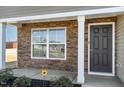 Close up of front porch with stone accents, black door, and manicured landscaping at 2902 Cullens Dr, Graham, NC 27253
