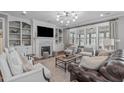 Bright living room with built-in shelving, fireplace, and large windows at 3608 Hillthorn Ln, Apex, NC 27539