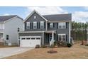 Beautiful two-story home showcasing gray siding, black shutters and well manicured front lawn at 3727 Horton Hill Dr, New Hill, NC 27562