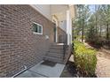 Brick steps lead to the front door with black railing, green bushes, and a covered porch at 4121 Sykes St, Cary, NC 27519