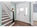 Bright entryway with a white front door, decorative molding, and hardwood floors leading to a staircase at 52 Reserve Dr, Fuquay Varina, NC 27526