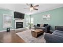 Comfortable living room with a fireplace, TV, large windows, hardwood floors, and stylish decor at 52 Reserve Dr, Fuquay Varina, NC 27526