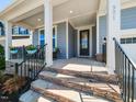 Inviting front porch featuring stone steps, black metal railings, and ample space for seating at 521 Ivy Arbor Way, Holly Springs, NC 27540