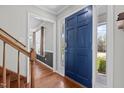 Inviting foyer featuring hardwood floors, a vibrant blue front door with sidelights, and a staircase at 5313 Wenesly Ct, Raleigh, NC 27616