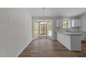 Dining area featuring a bay window, stylish chandelier, and seamless transition to the modern kitchen at 5408 Rivercrest Dr, Youngsville, NC 27596