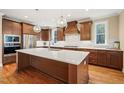 Spacious kitchen features an island with quartz countertops, stainless appliances, and hardwood floors at 56 Mist Wood Ct, Pittsboro, NC 27312