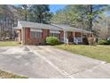 Property featuring a brick exterior, a long driveway, and manicured landscaping at 5630 Jones Sausage Rd, Garner, NC 27529