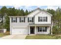 Charming two-story home features a two-car garage and classic black shutters set against a backdrop of lush, mature trees at 709 Conifer Ct, Creedmoor, NC 27522