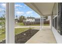 Inviting covered porch with classic white columns offers a relaxing outdoor space with views of the quiet, tree-lined street at 709 Conifer Ct, Creedmoor, NC 27522