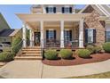 Inviting front porch with stone steps and beautiful landscaping at 804 Cambridge Hall Loop, Apex, NC 27539