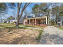 Lovely brick home with a spacious covered porch, surrounded by mature trees and a lush lawn at 818 Eastern Ave, Rocky Mount, NC 27801