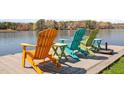Colorful Adirondack chairs sit lakeside, offering a tranquil spot to relax and enjoy the view at 923 Sagamore Dr, Louisburg, NC 27549