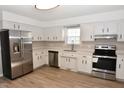 Bright kitchen features stainless steel appliances, white cabinets, and light wood-look flooring at 107 Ware Ct, Garner, NC 27529