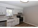 A kitchen with white cabinets, stainless steel appliances, and a window above the sink at 107 Ware Ct, Garner, NC 27529