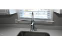 Close-up of the stainless steel kitchen sink and faucet with a window view at 107 Ware Ct, Garner, NC 27529