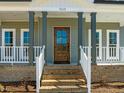 Inviting front entrance with a wood door and well-maintained landscaping at 109 Little Lady Trail, Zebulon, NC 27597
