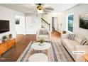 Bright, staged living room featuring modern furniture, hardwood floors, and ample natural light at 1100 Walter Clark Dr, Hillsborough, NC 27278