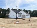 Side view of a well-maintained white house with green trees in the background at 136 Tee Time Ter, Benson, NC 27504