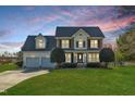 Beautiful two-story home featuring a manicured lawn and classic architectural details at dusk at 154 Ashton Ln, Angier, NC 27501