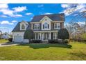 Charming two-story home features a well-kept lawn, a two-car garage, and mature landscaping at 154 Ashton Ln, Angier, NC 27501