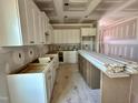 Unfinished kitchen features white cabinets, an island, and lots of space for customization at 163 Noramac Ct, Selma, NC 27576