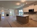 Open concept kitchen with stainless steel appliances, an island, with views to the fireplace in the living room at 163 Noramac Ct, Selma, NC 27576