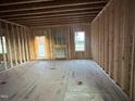 A large unfinished living area with stud walls, subfloors, windows and a back door at 163 Noramac Ct, Selma, NC 27576