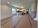 Open concept living room and kitchen with lots of natural light and views of the entry staircase at 163 Noramac Ct, Selma, NC 27576