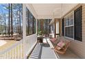 Relaxing covered porch with a porch swing, table, and outdoor rug, perfect for enjoying the outdoors at 170 Buckaroo Dr, Louisburg, NC 27549