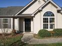 Close-up of the home's entrance showcasing the black front door, arched window, and manicured landscaping at 216 Orkney Rd, Stem, NC 27581