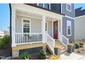 Inviting front porch with a red door and decorative flower pots on the steps at 236 Annabelle Blue Dr, Wake Forest, NC 27587