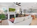 Open-concept living room with a fireplace, ceiling fan, and view into the modern kitchen at 236 Annabelle Blue Dr, Wake Forest, NC 27587