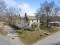 Two-story home featuring green roof, inviting porch, and blossoming tree at 2409 Hodges Rd, Burlington, NC 27217
