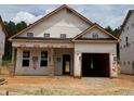 Unfinished exterior of a single-Gathering home with a two-car garage and covered porch, showcasing the initial construction phase at 346 Bluejay St, Clayton, NC 27520