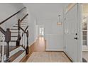 Bright foyer with hardwood floors, staircase, and modern lighting at 3509 Archdale Dr, Raleigh, NC 27614