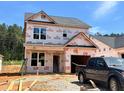 Two-story home under construction, featuring a visible garage and stairs leading to the front door on a sunny day at 354 Bluejay St, Clayton, NC 27520