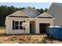 New construction home with light siding, black shutters, and an open garage, set in a partially landscaped yard at 362 Bluejay St, Clayton, NC 27520