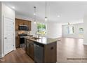 Modern kitchen boasts stainless steel appliances, sleek granite countertops, and opens into the living area at 378 Bluejay St, Clayton, NC 27520
