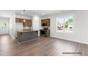 Open concept kitchen featuring granite island, stainless appliances, and wood flooring at 378 Bluejay St, Clayton, NC 27520