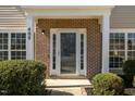 Inviting front entrance featuring a brick facade, sidelights, and well-maintained landscaping at 409 Sapphire Dr, Durham, NC 27703