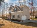 Two-story home with a front porch and a side-entry garage on a well-manicured lawn at 424 Hocutt Farm Dr, Clayton, NC 27527
