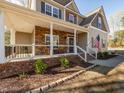 Inviting home exterior with a stone and brick porch, complemented by a well-maintained lawn at 424 Hocutt Farm Dr, Clayton, NC 27527