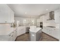 Bright kitchen featuring white cabinets, stainless steel appliances, a central island, and hardwood flooring at 4320 Stony Falls Way, Knightdale, NC 27545